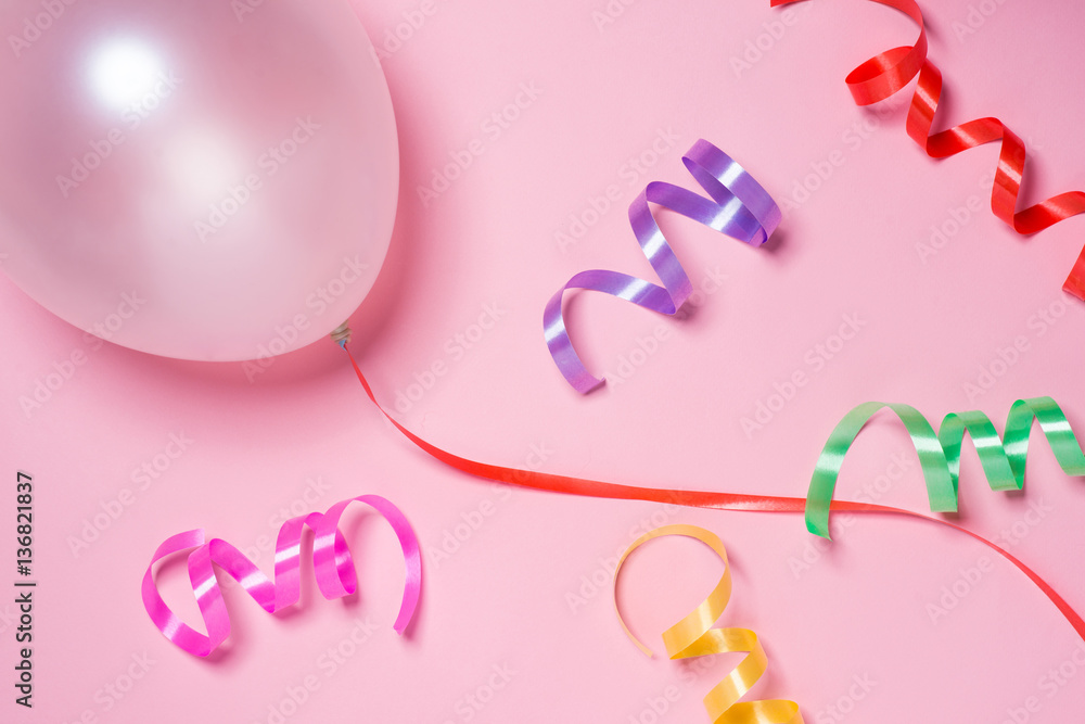 Festive ribbon and white balloon isolated on pink background