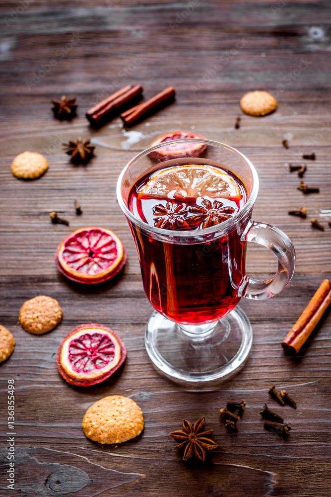 mulled wine with spices in cup on wooden background