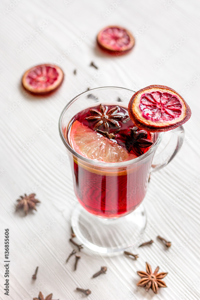 mulled wine with spices in cup on wooden background