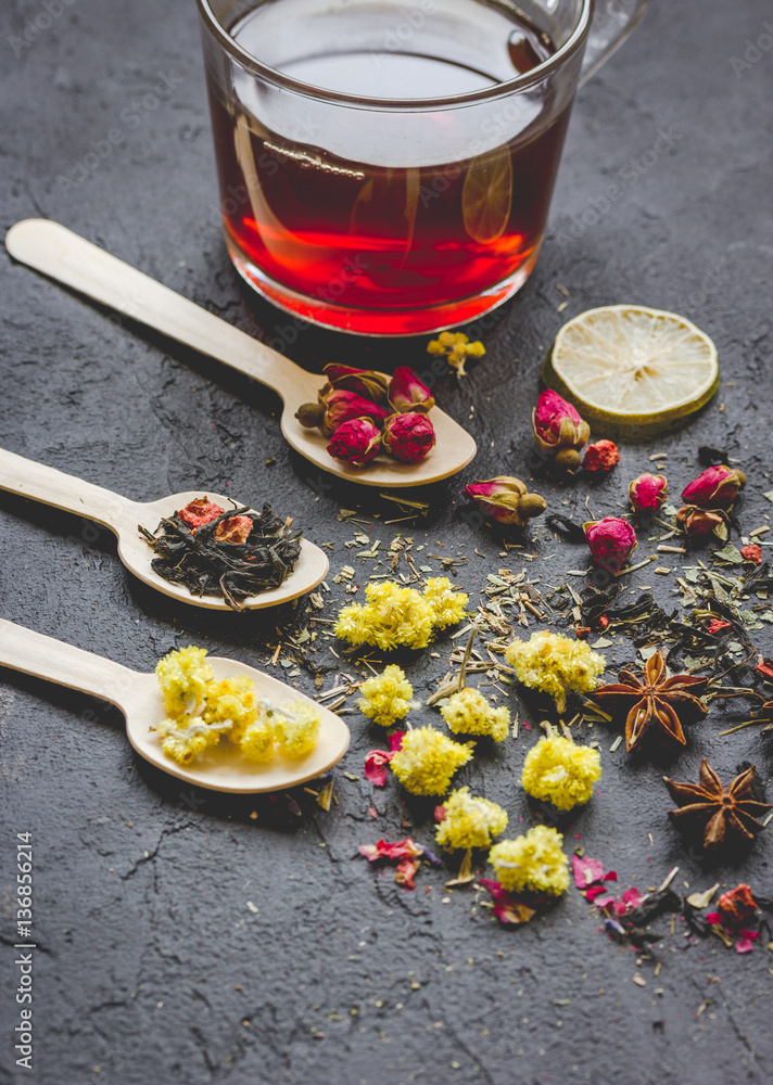 Teacup and herbs on grey background