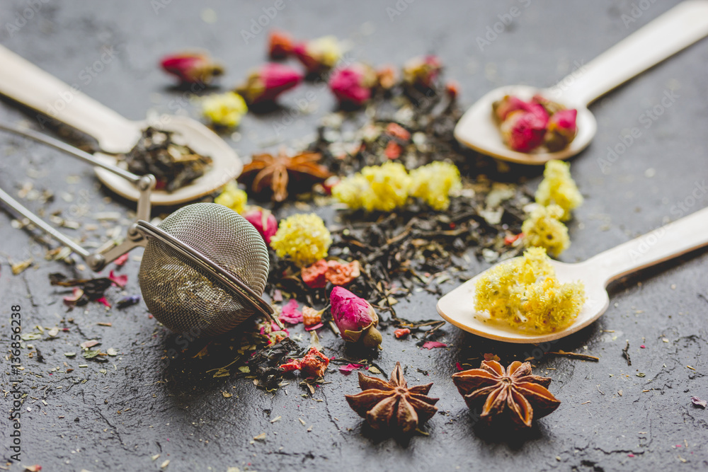 Tea herbs and spoons on grey background