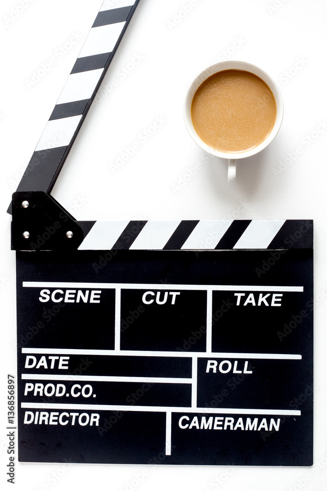 Screenwriter desktop with movie clapper board white background top view