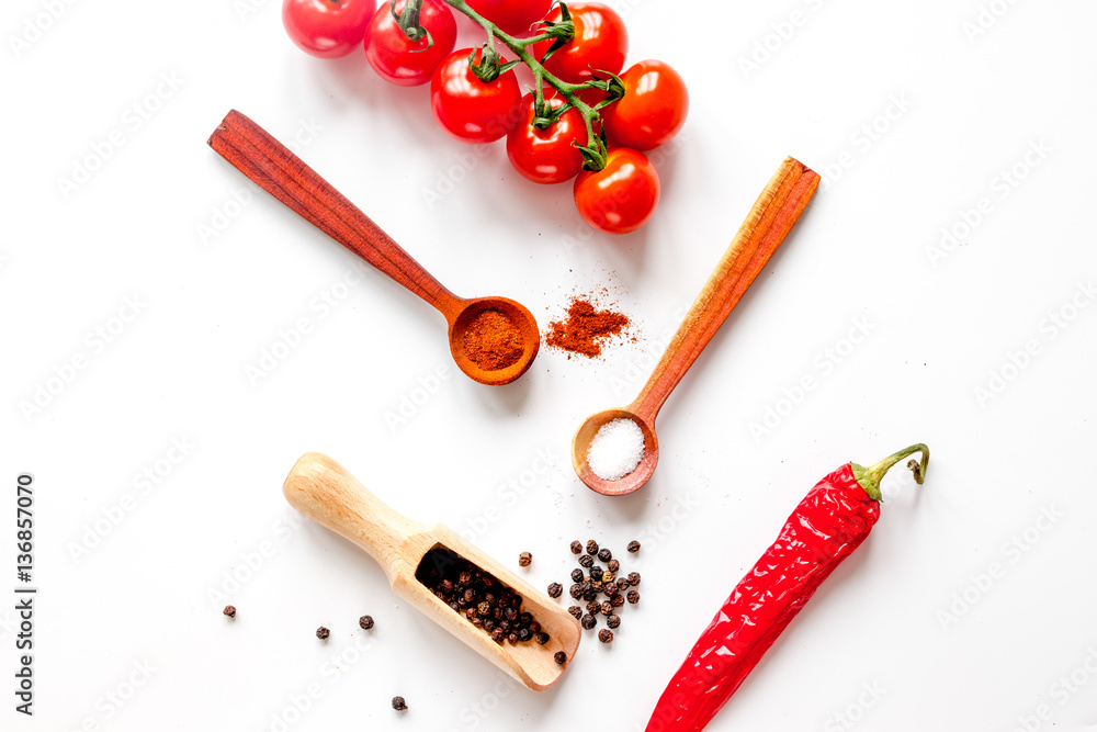 spices in wooden spoon on white background top view