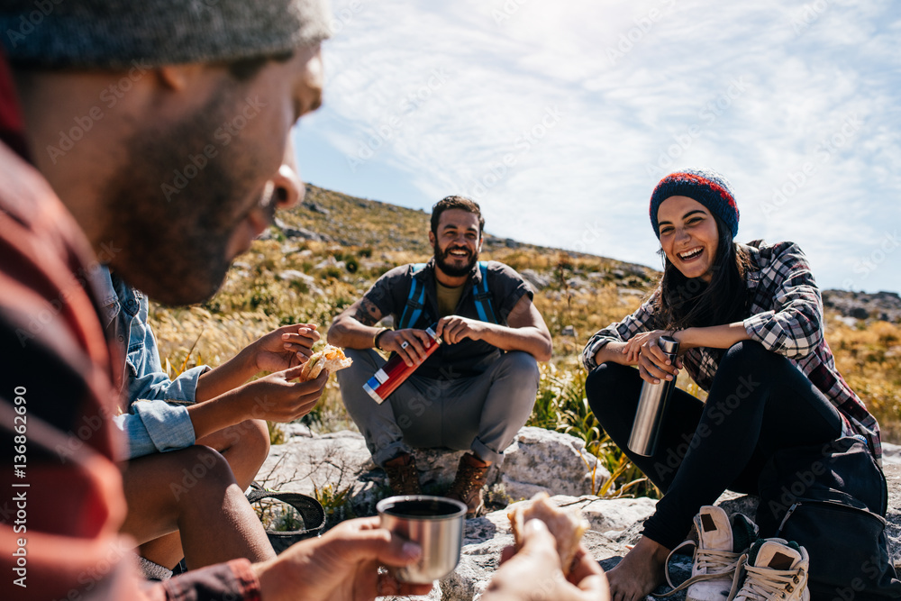 Group of people relaxing and eating during hike