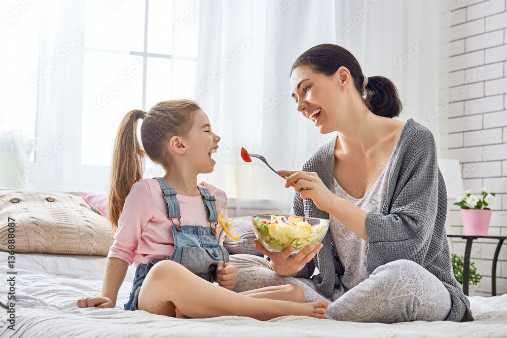 Mother and daughter eating salad