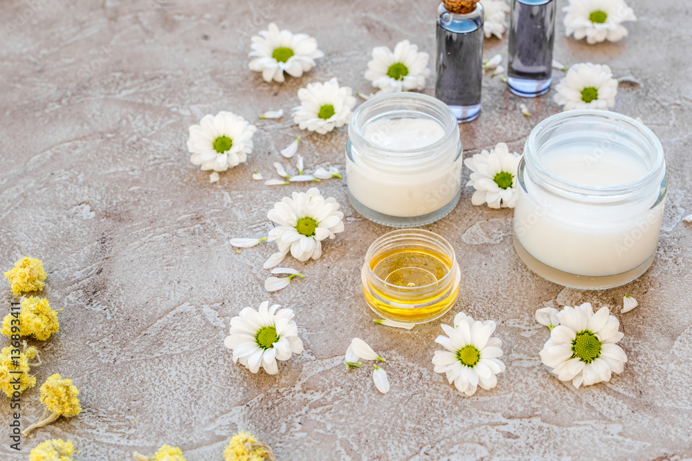 organic cosmetics with camomile on stone background