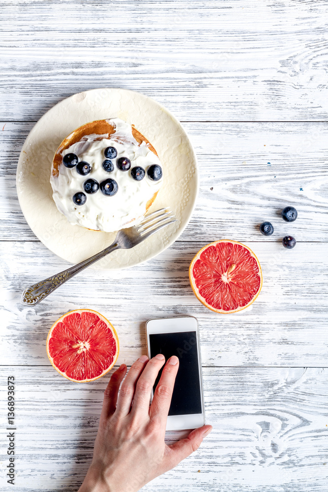 Breakfast concept with flowers on wooden background top view