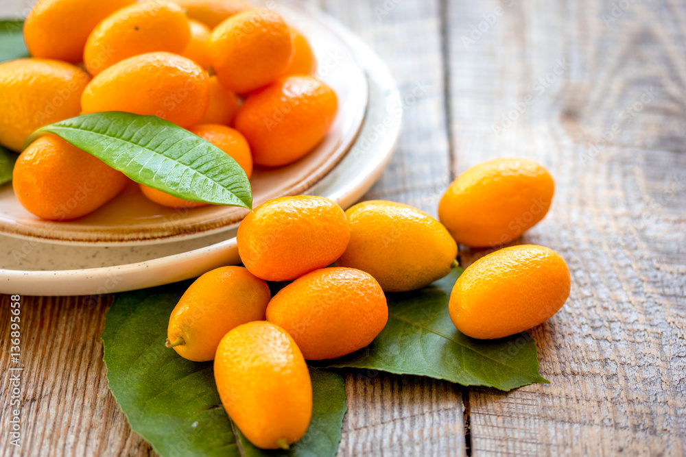 kumquat on plate at wooden table