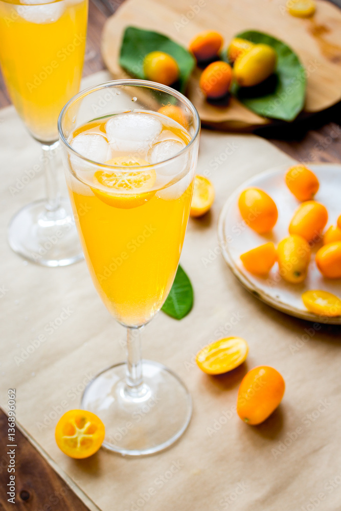 cocktail with kumquat on wooden background