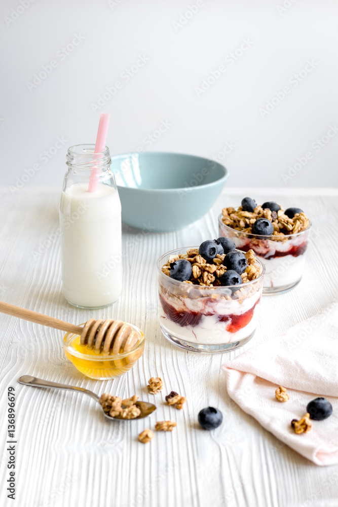 Cooking breakfast with granola and berries on white kitchen background