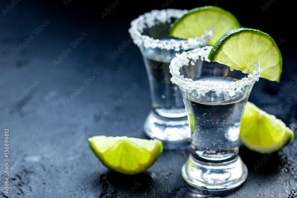 Alcohol shots with lime and salt on black background