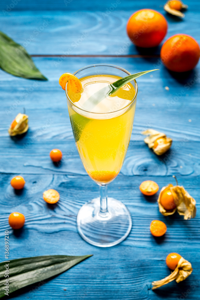 cocktail with physalis in glass on wooden background