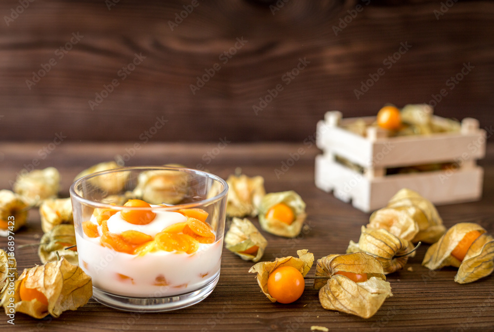 yogurt with physalis on wooden background