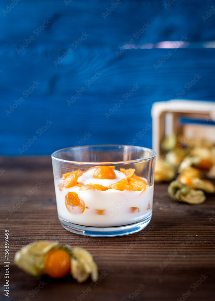 yogurt with physalis on wooden background