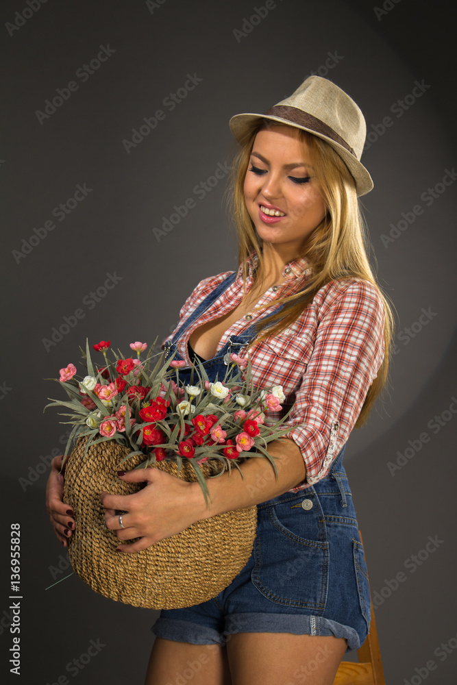 Young beautiful  woman in shorts with basket of flower.