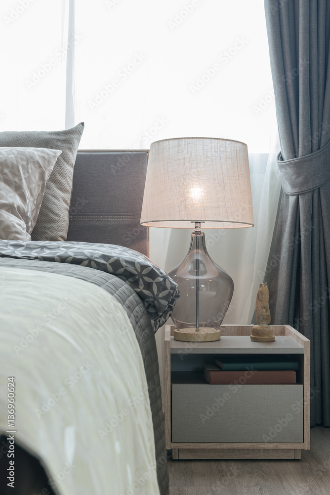 classic lamp style with alarm clock on table side in cozy bedroo