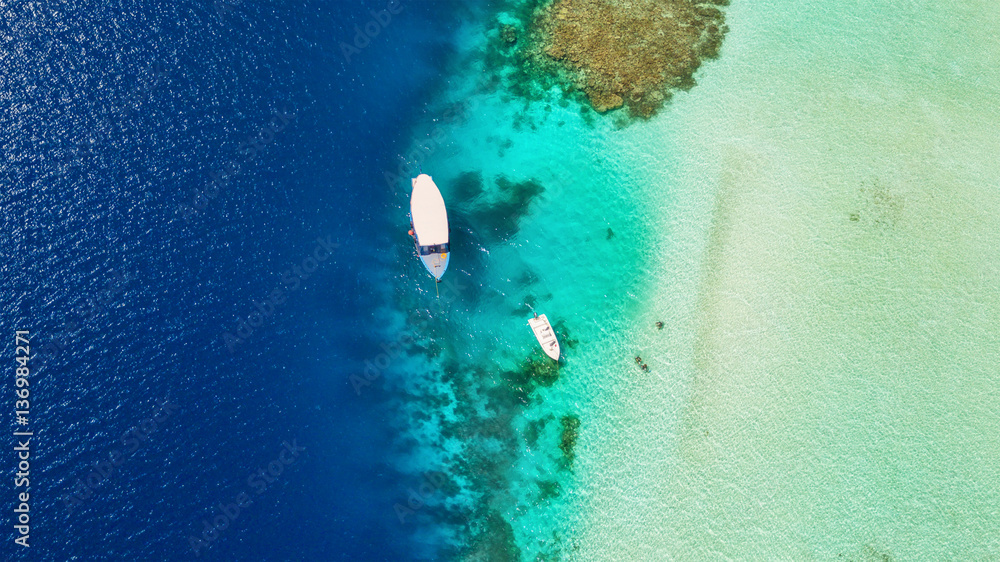 Beautiful coral reef with anchoring boats