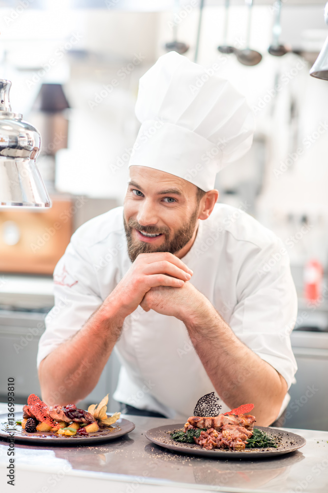 Portrait of chef cook in uniform with prepaired delicious dish at the restaurant kitchen