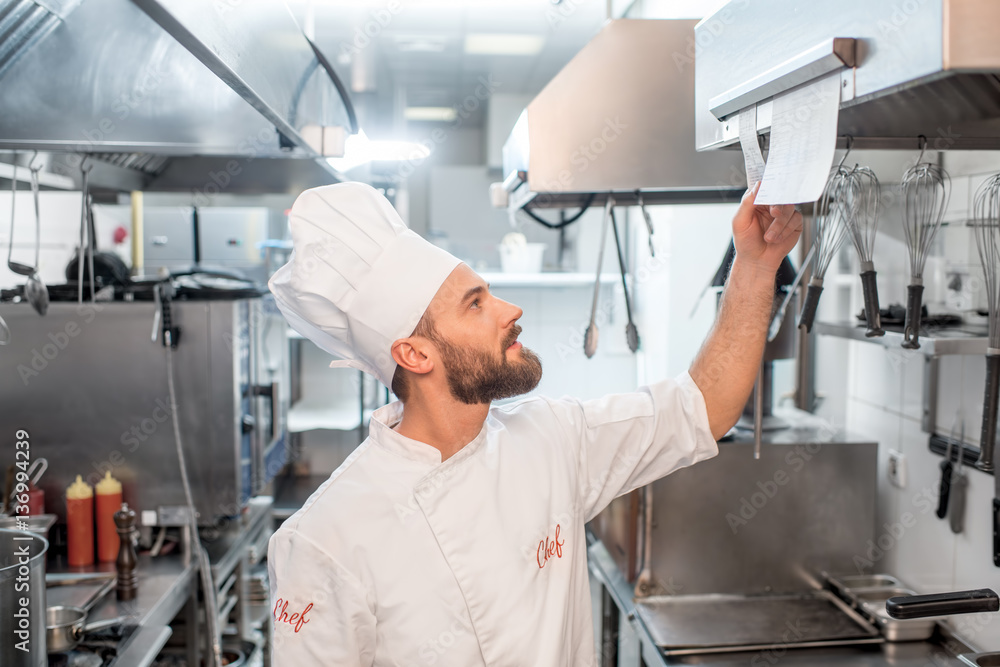 Chef cook checking the order at the restaurant kitchen