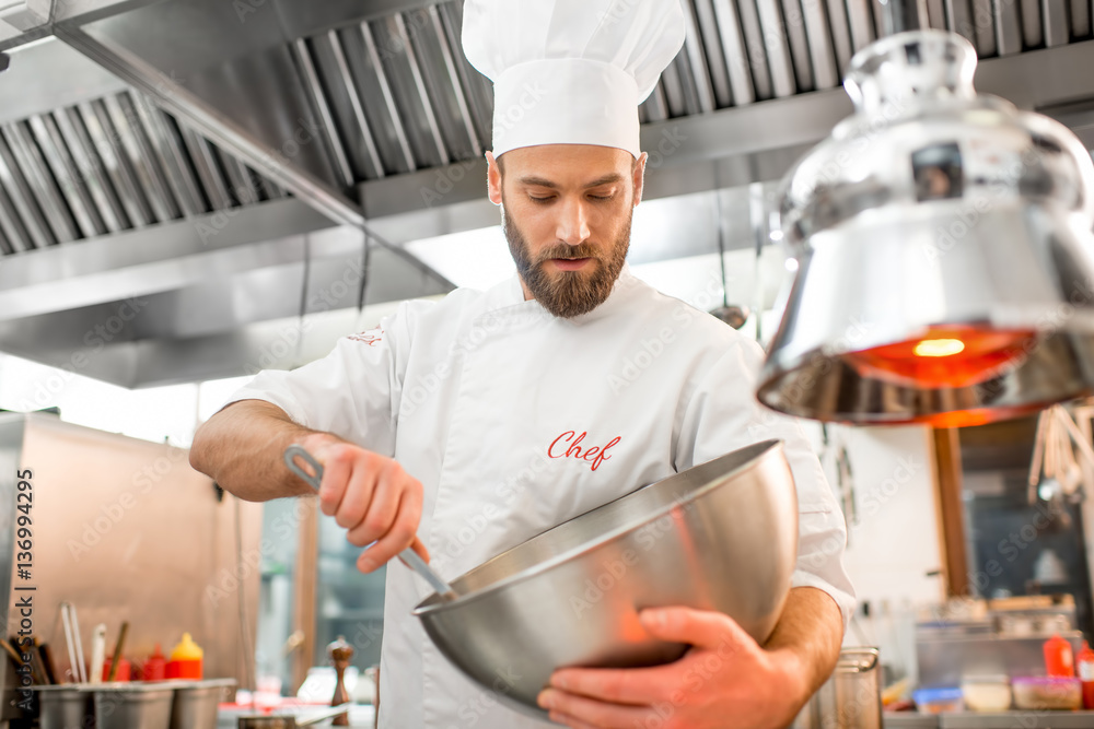 Chef cook mixing salad at the restaurant kitchen