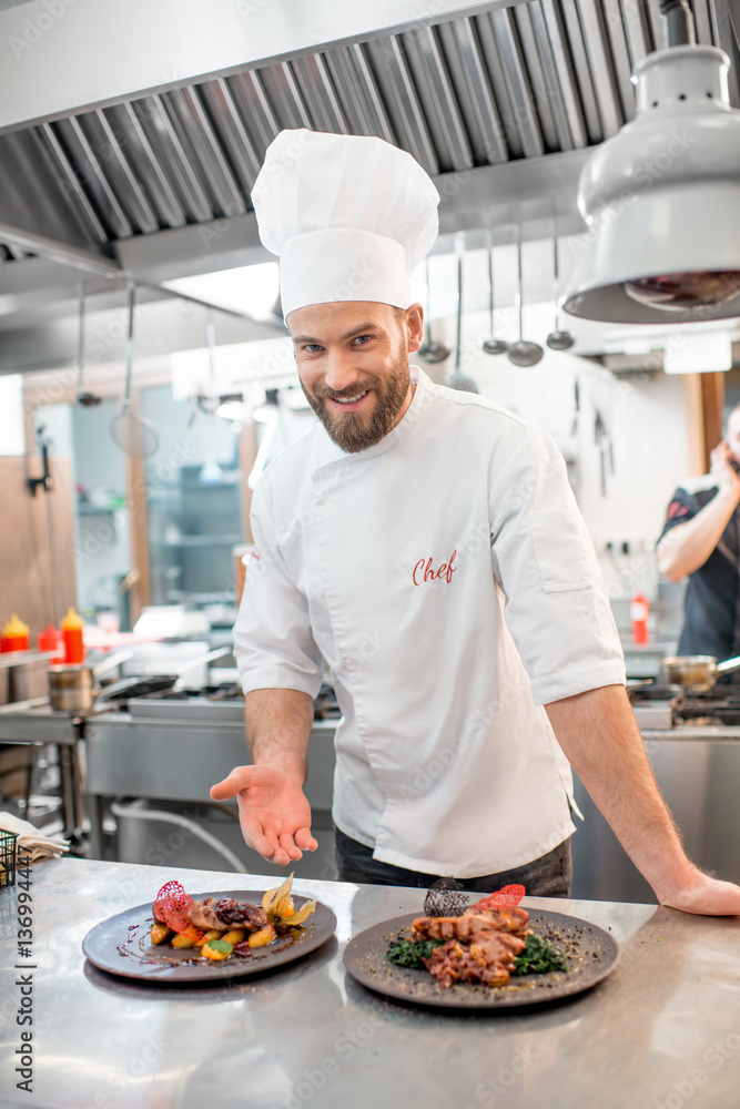 Portrait of chef cook in uniform with prepaired delicious dish at the restaurant kitchen