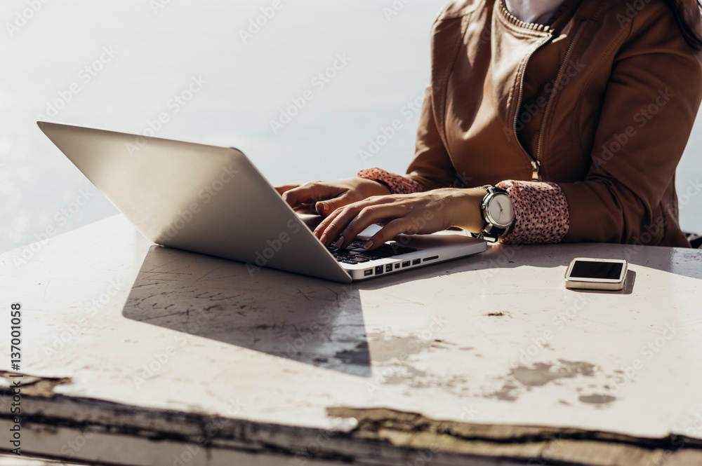 Close up shot of female hands typing on a laptop keyboard.