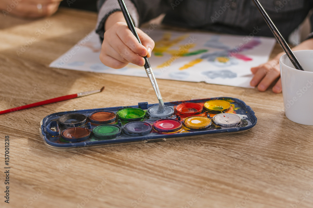 Little kid draws with water colors