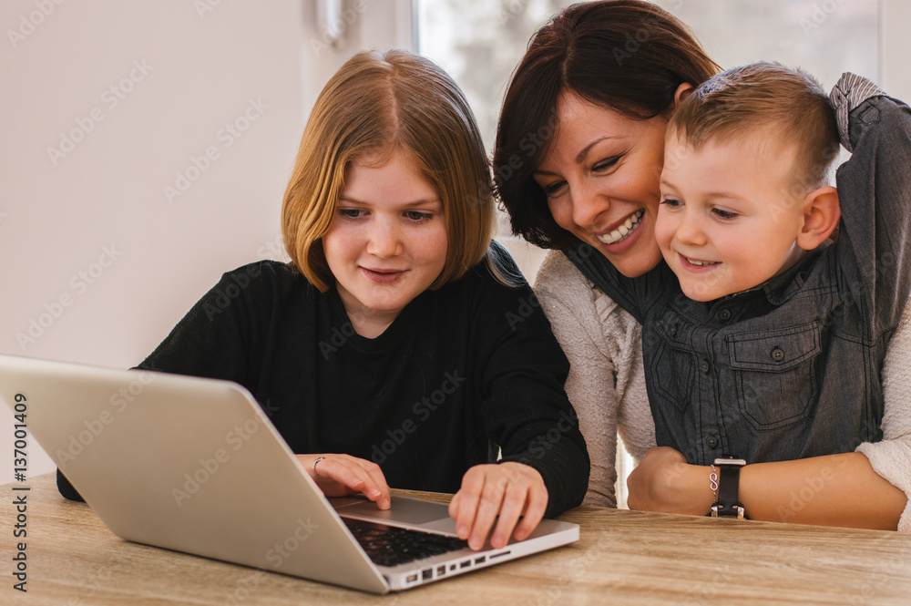 Family of three playing on laptop