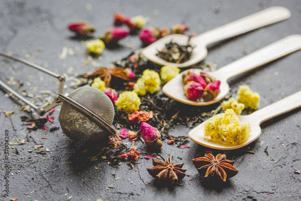 Tea herbs and spoons on grey background