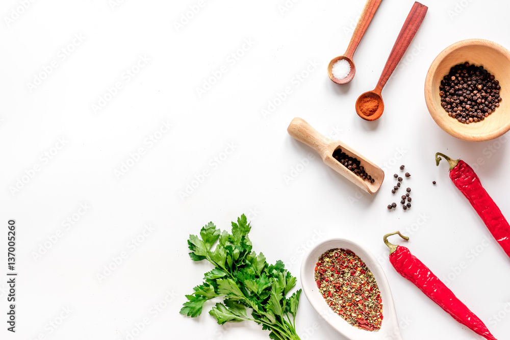 spices in wooden spoon on white background top view