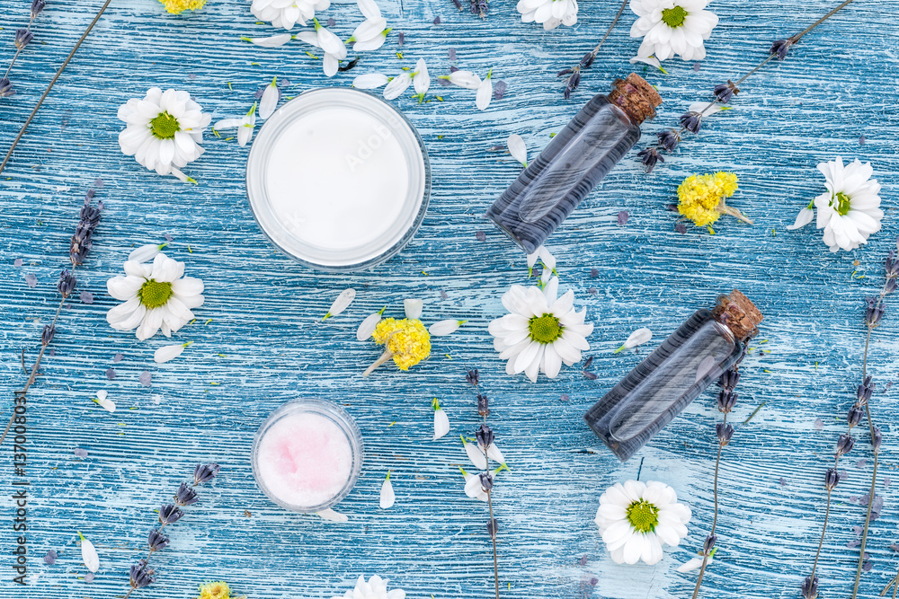 organic cosmetics with camomile on blue background top view