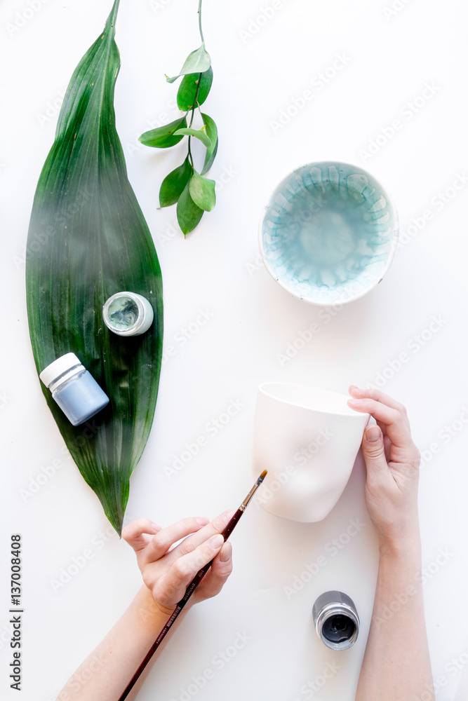 painted ceramic cup on white background top view