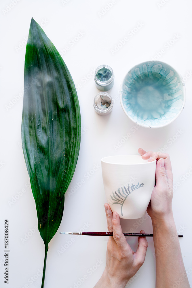 painted ceramic cup on white background top view