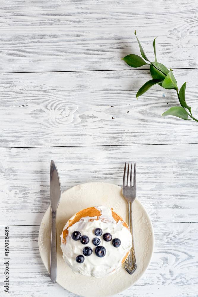 Breakfast concept with flowers on wooden background top view