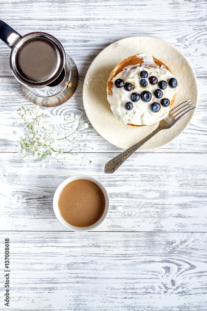 Breakfast concept with flowers on wooden background top view