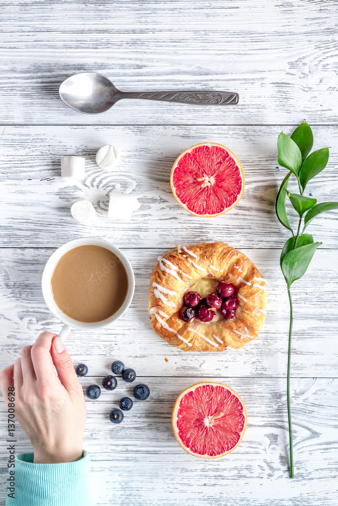 Breakfast concept with flowers on wooden background top view