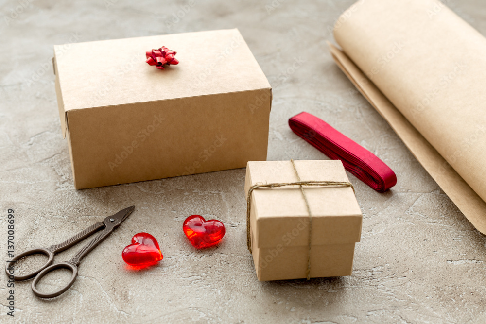 wrapping gifts in box for holiday on stone background