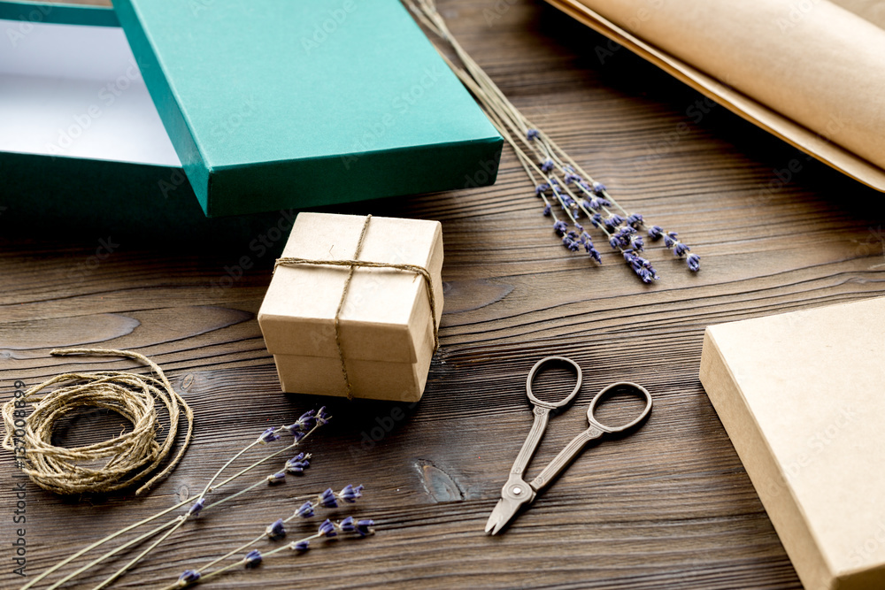 wrapping gifts in box for holiday on wooden background