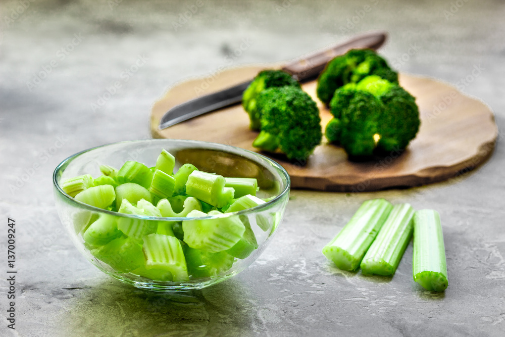 Green vegetable smoothie in glass at gray background