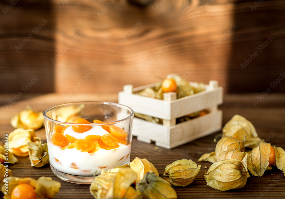 yogurt with physalis on wooden background