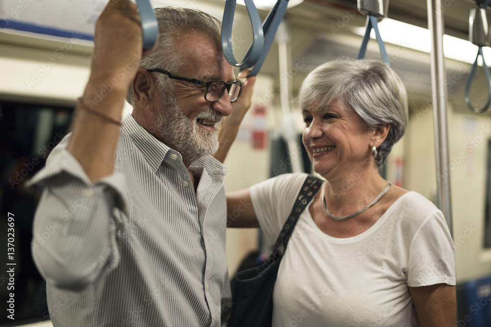 Senior couple traveling inside train subway