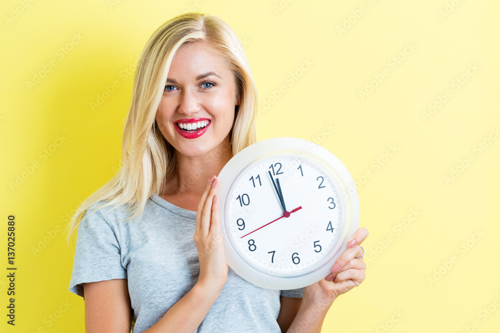  Woman holding clock showing nearly 12