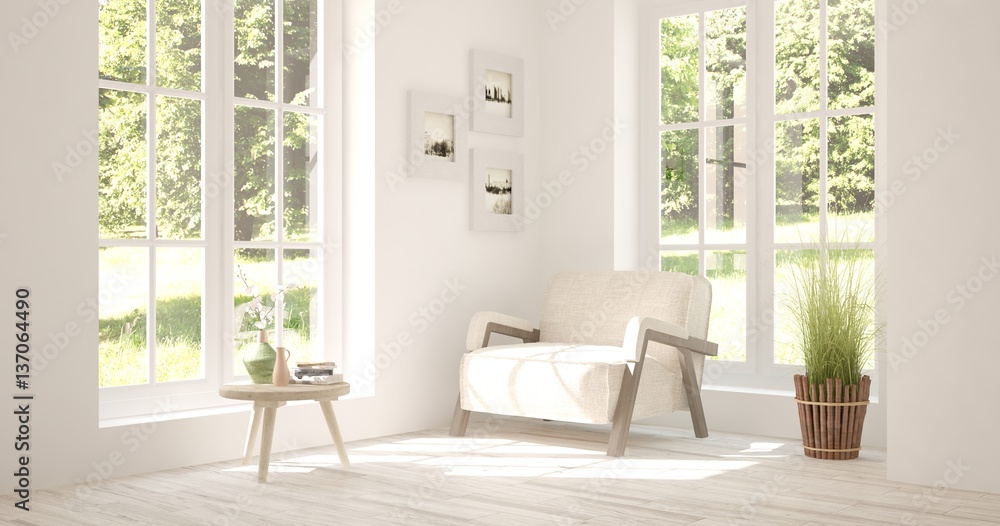 White room with armchair and green landscape in window. Scandinavian interior design