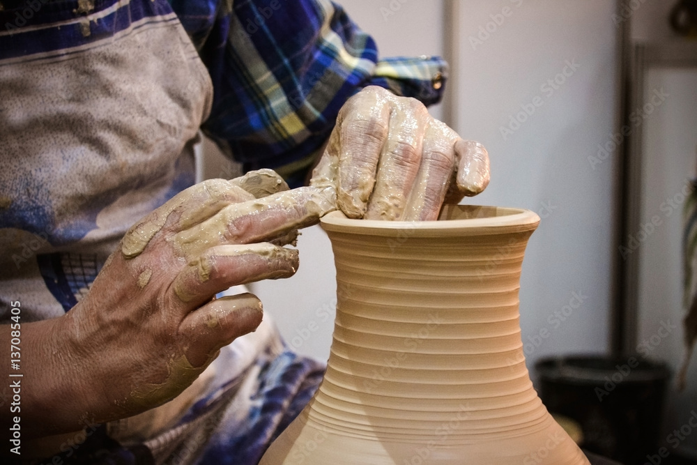 The potter molds clay jug pot closeup. Workshop on sculpt white clay closeup. Dirty hands in the cla