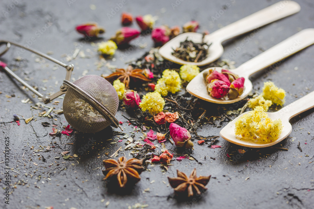 Tea herbs and spoons on grey background