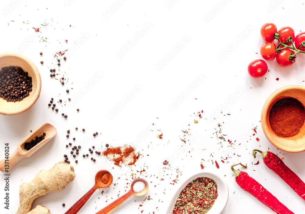 spices in wooden spoon on white background top view