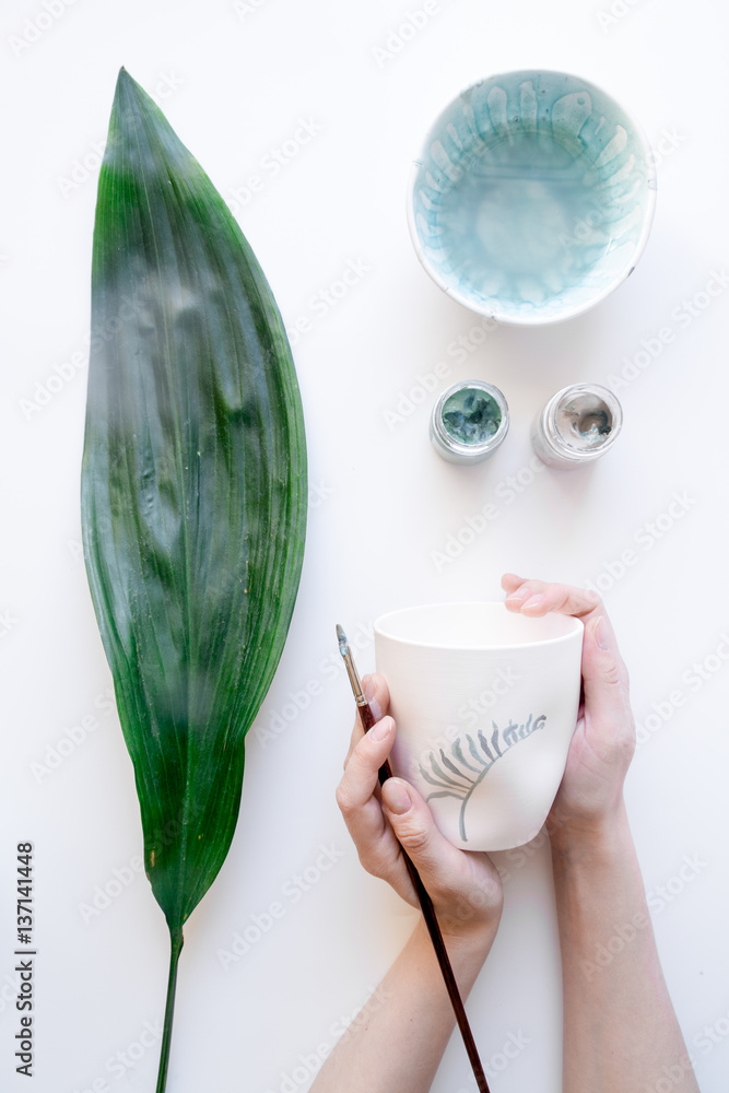 painted ceramic cup on white background top view