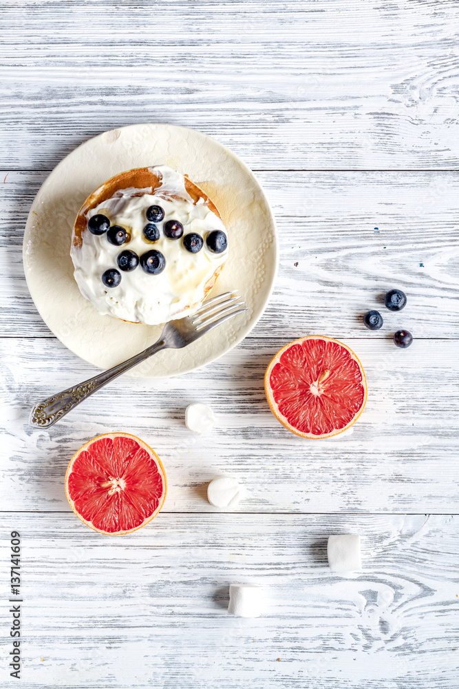 Breakfast concept with flowers on wooden background top view