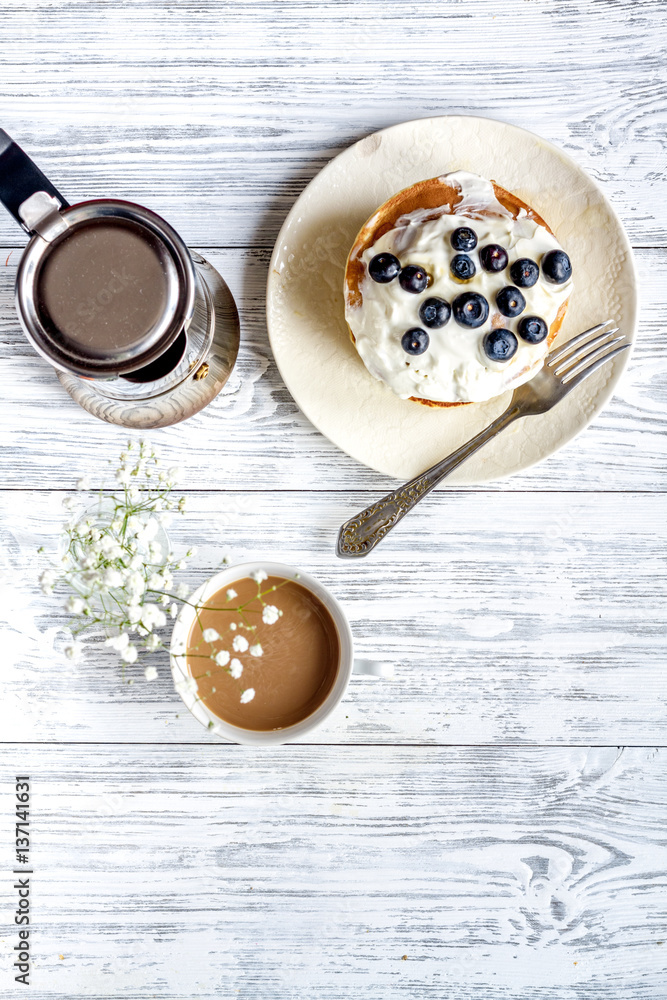 Breakfast concept with flowers on wooden background top view