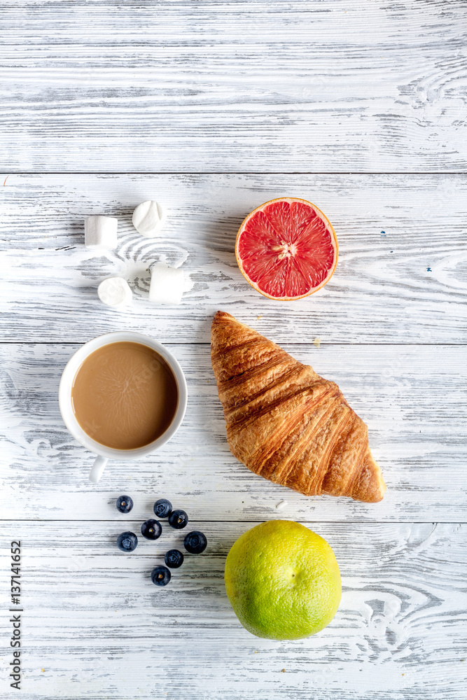 Breakfast concept with flowers on wooden background top view